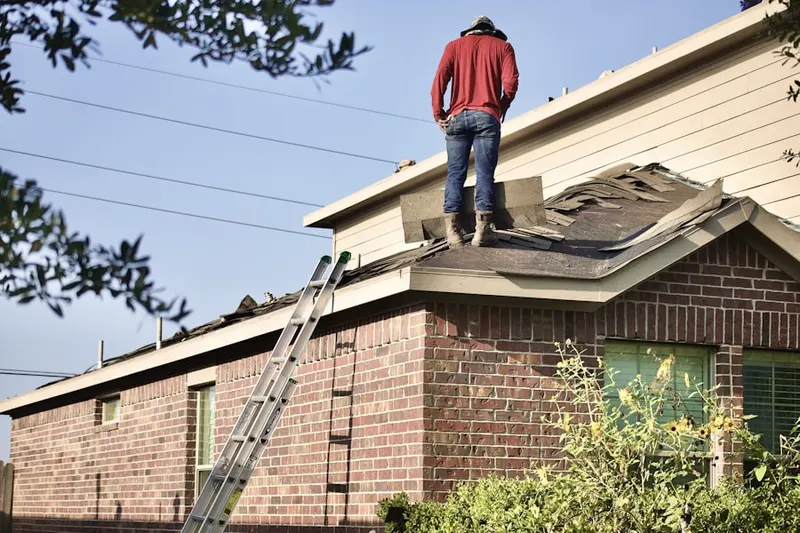 Professional roofer working on a residential roof in Ionia